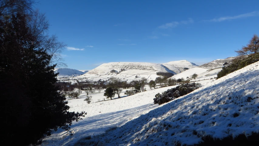 the mountains are covered in snow and trees