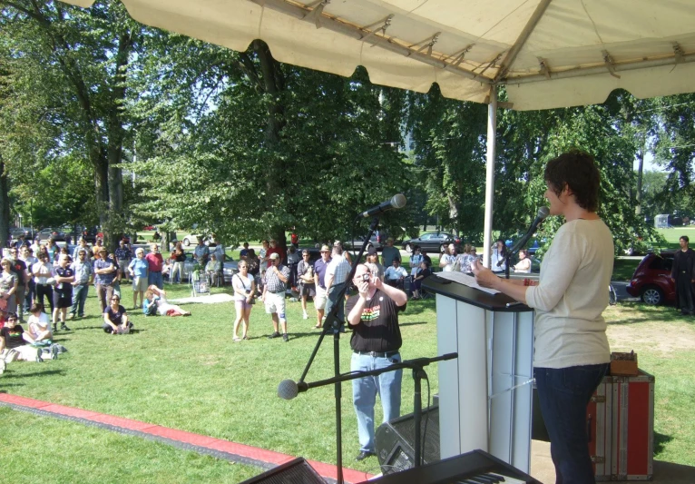 a woman stands at the podium during a crowd