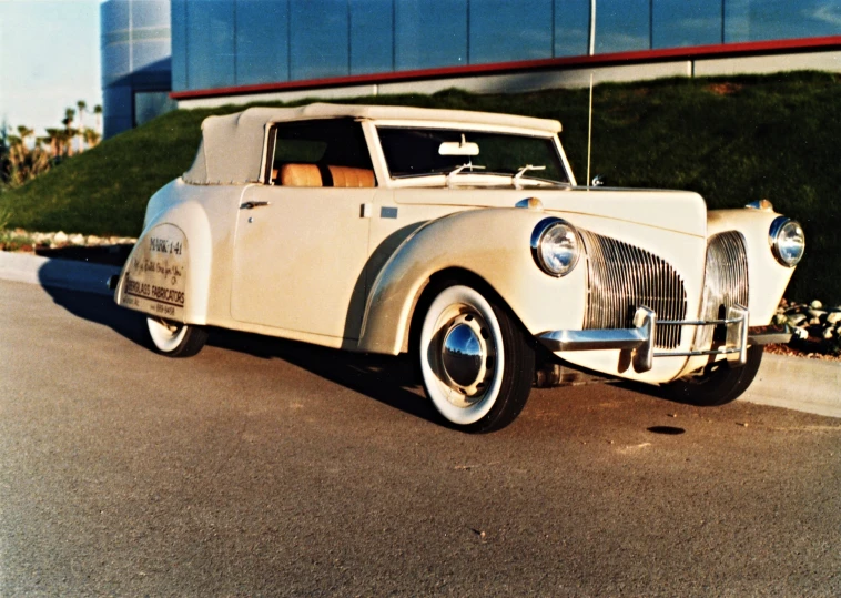 an antique car parked next to a tall building