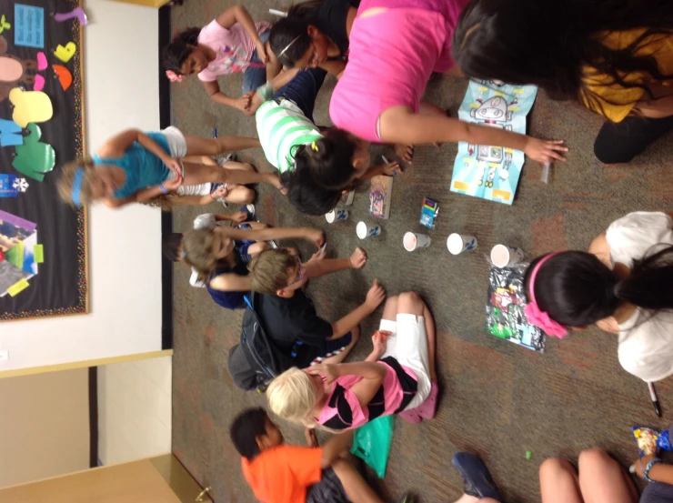 s are in a circle reading books and painting on the floor