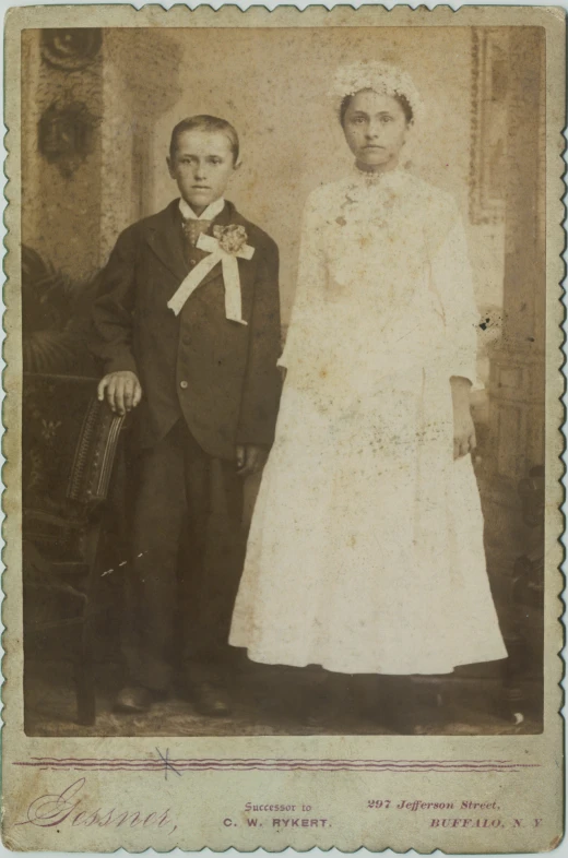 an old - fashioned po of a boy and girl dressed in formal dress