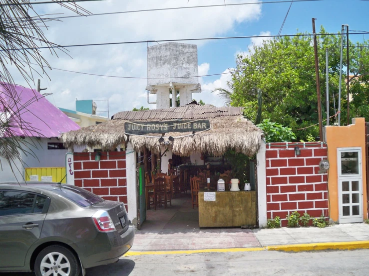 a car parked outside of a brick bar with an entrance