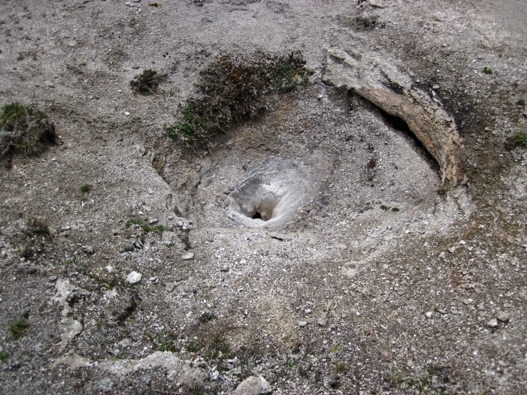 an open hole in the ground surrounded by rocks