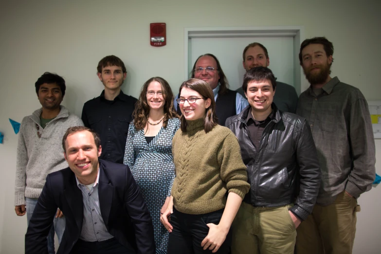 a group of men and women pose together for a po