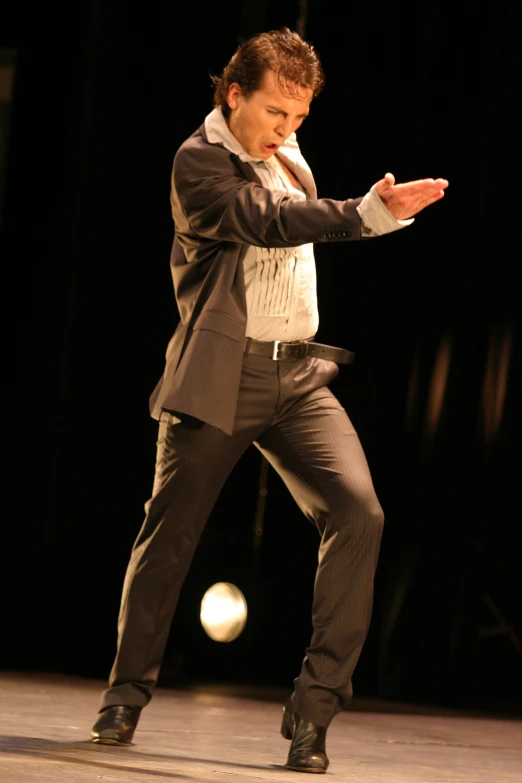 a man in grey suit standing on a stage