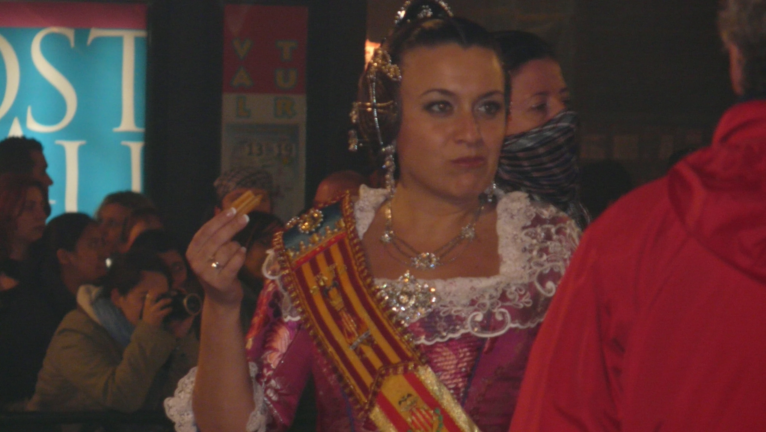 a woman wearing a fancy, fancy dress stands next to a man with a large crown