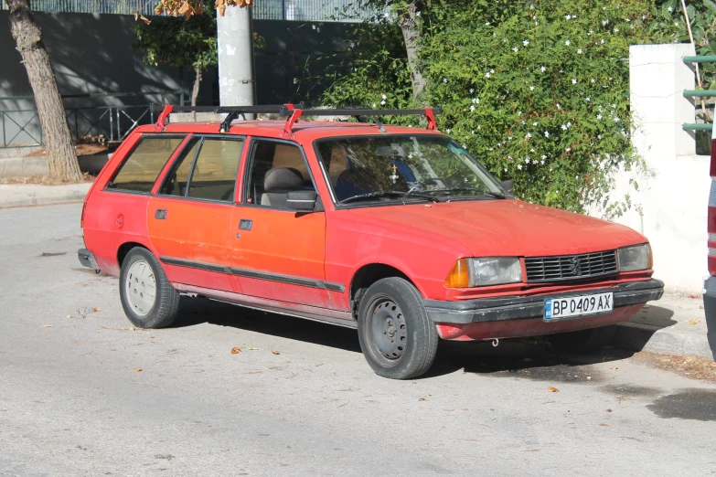 an orange station wagon parked on the side of a road