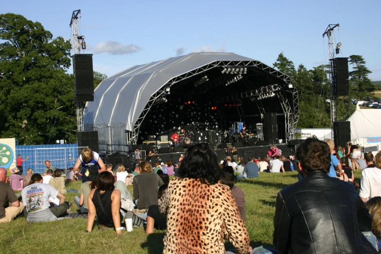 a large crowd at a concert watching a band perform