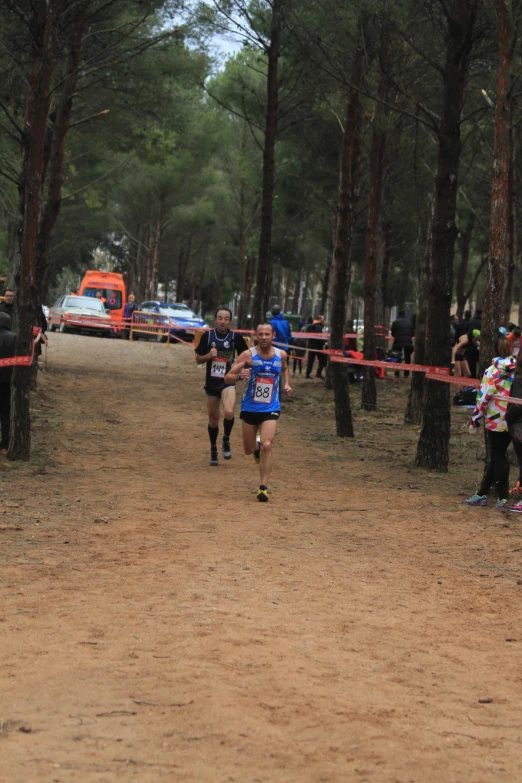 a man racing in a competition, wearing a blue shirt