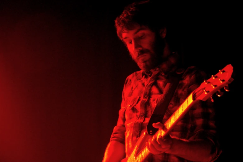 a man is standing with an electric guitar in his hand