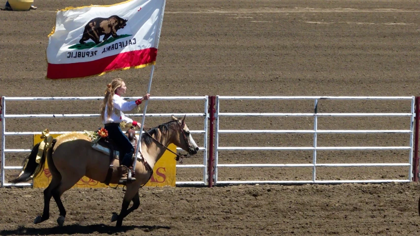 the woman is riding her horse holding the flag