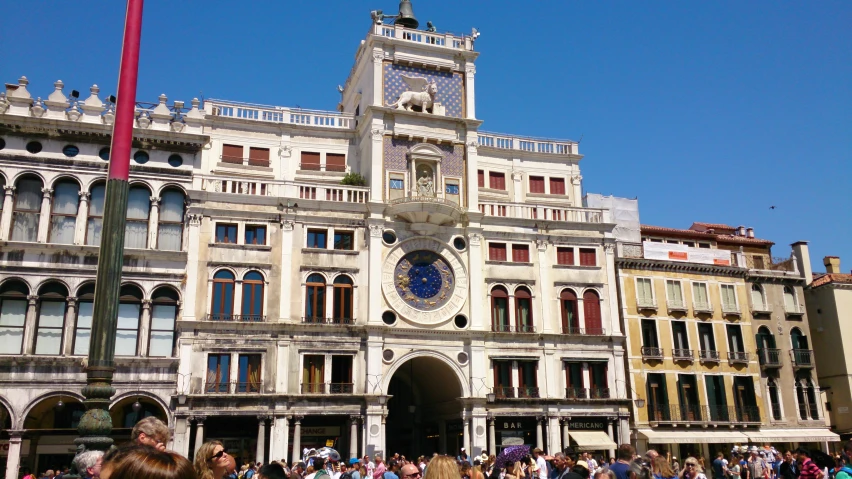 a group of people gather around a large building