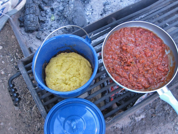 two dishes of food sit on a bbq