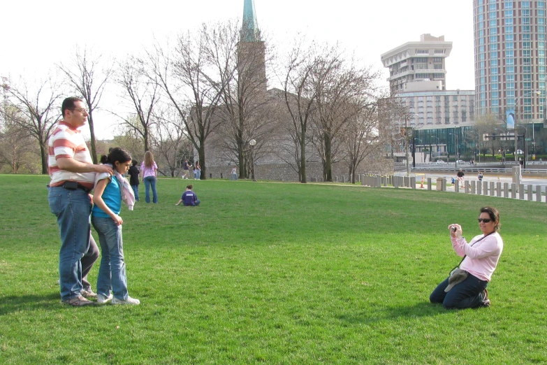people sitting on the ground taking pictures of them in a park