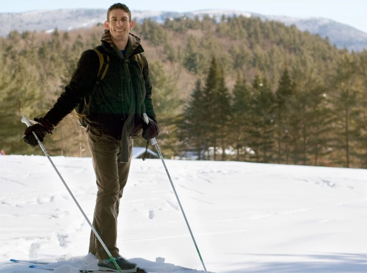 a man in a black jacket skiing on a flat surface