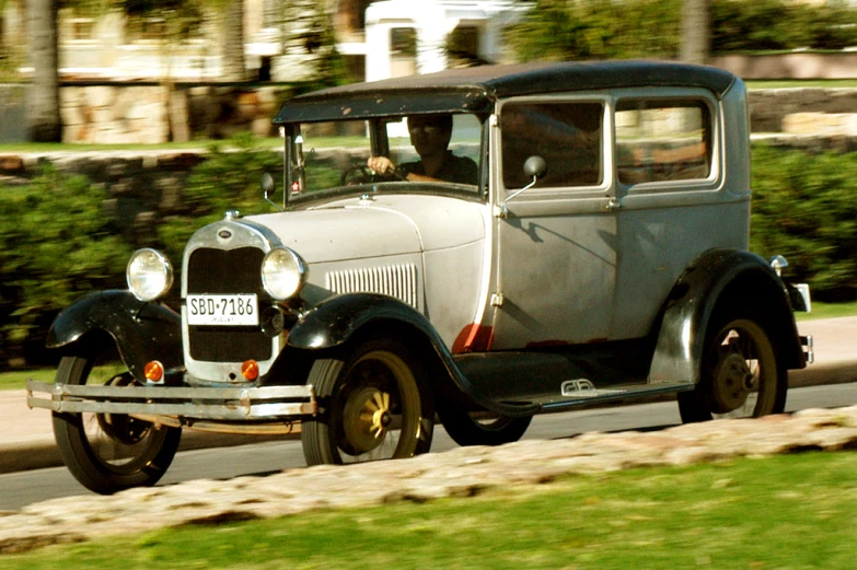 an old fashion model ford is driving down the street