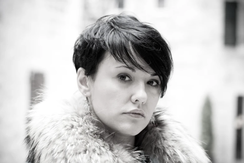 a woman with dark hair and a furry coat