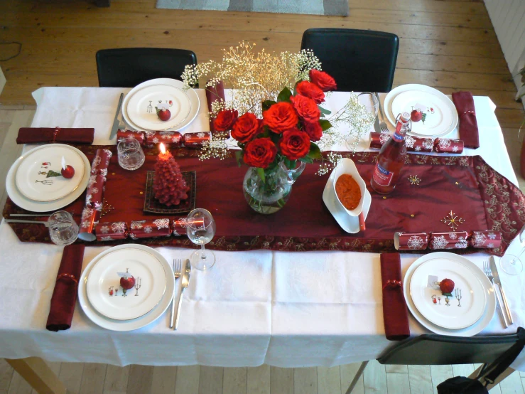 red and white dinner table setting with rose centerpiece