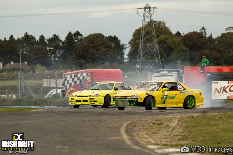 yellow cars racing on a race track with smoke