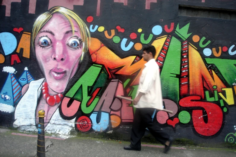 a person walking past a colorful art work on a wall