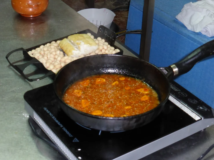 a  pot with beans in it near another pot on a stove