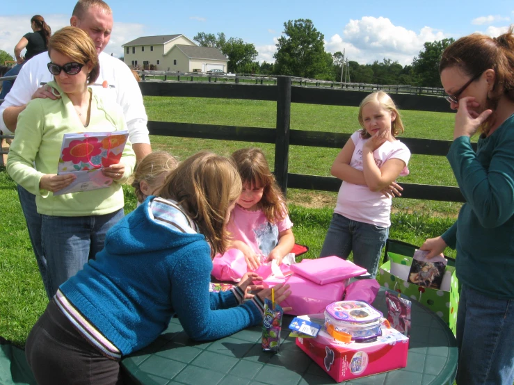 a  is getting ready to open her birthday cake at the park