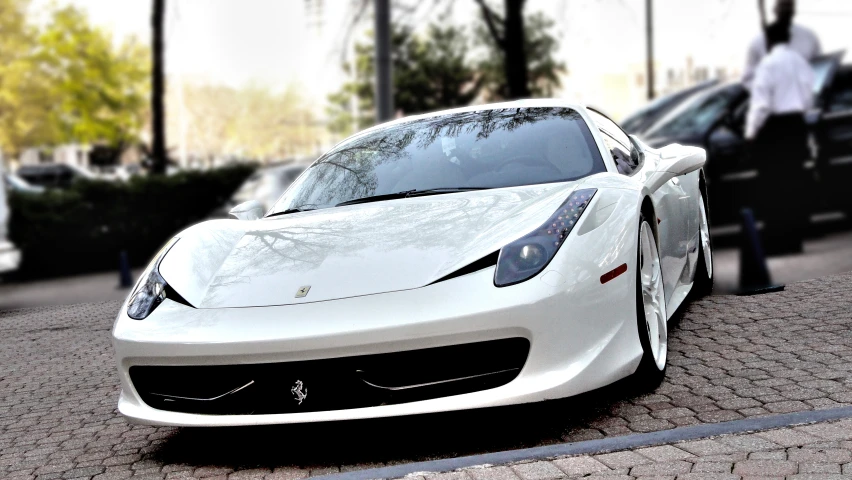 the white sports car is parked in the street