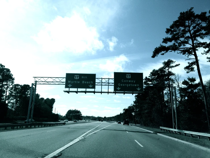 a highway that is empty with two signs above it