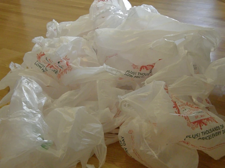 many bags of trash sitting on top of a wood floor