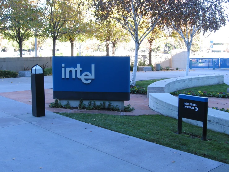 a building sign is in front of a grass field and trees