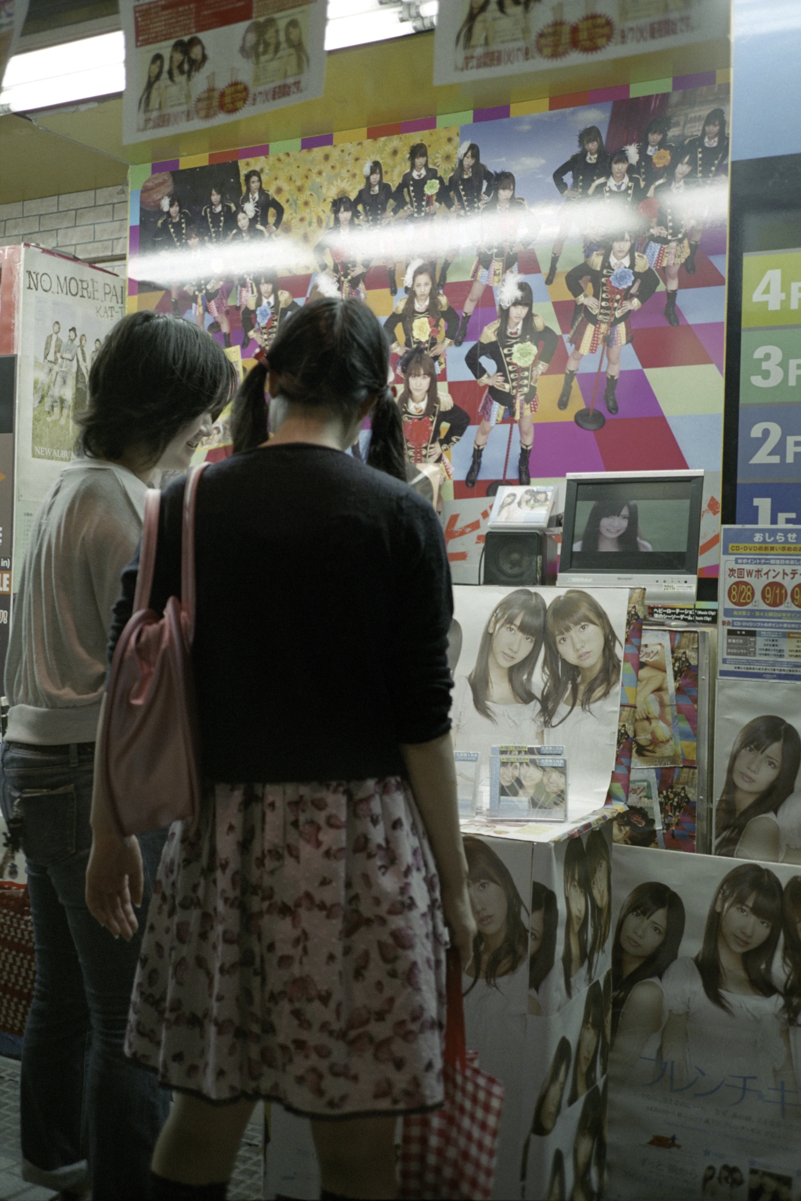 people looking at posters in a store window