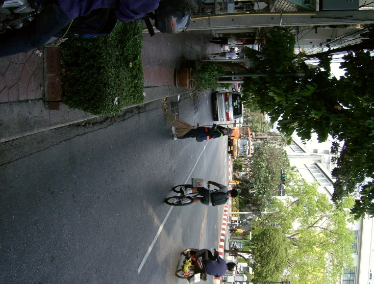 a group of people walking down a street near a line of parked bikes