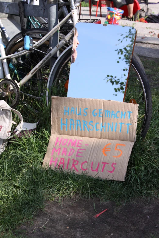 a sign near a bicycle that reads fair grounds hamburg and hate lies on the ground