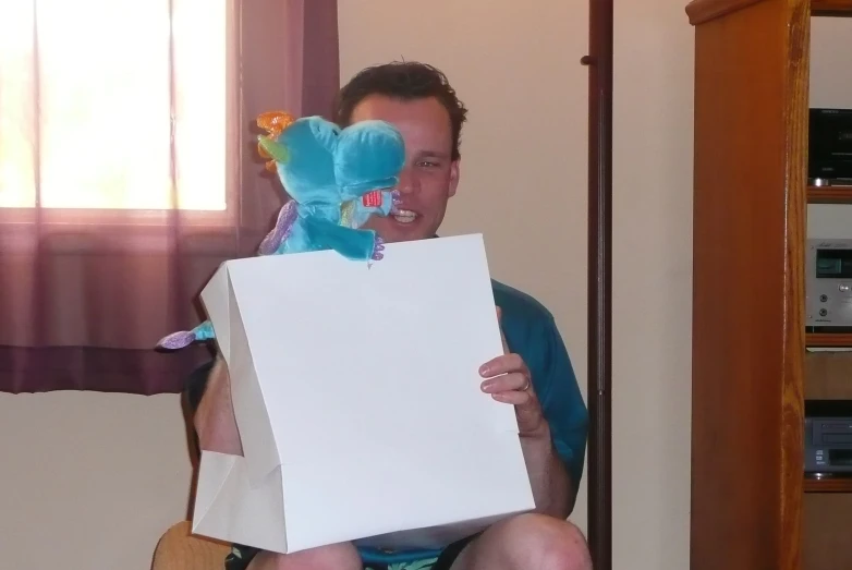 a man sitting on a couch holding up an empty sign