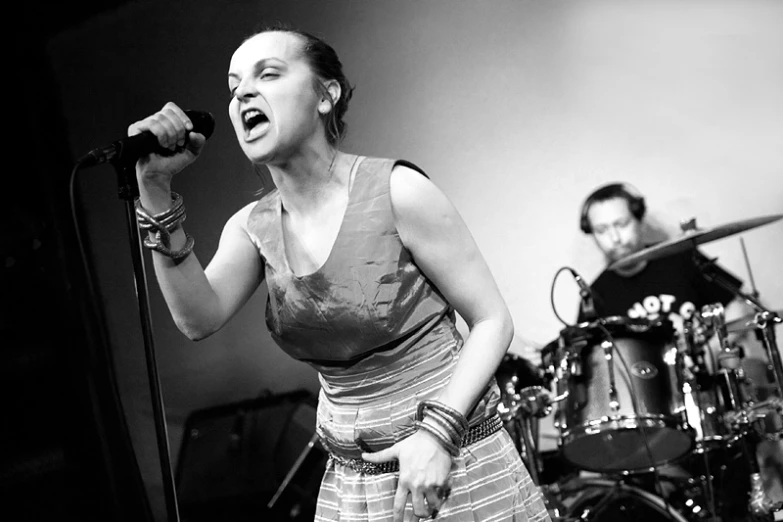 black and white image of a woman singing into a microphone