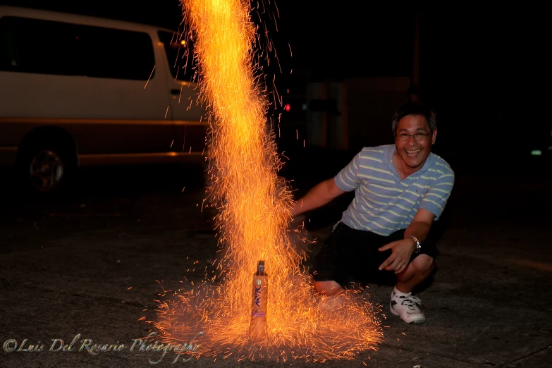 a man kneeling down with some bright sparks around him
