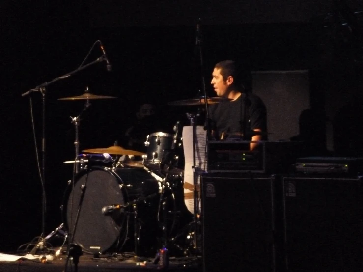 a young drummer is looking over the top of the drums