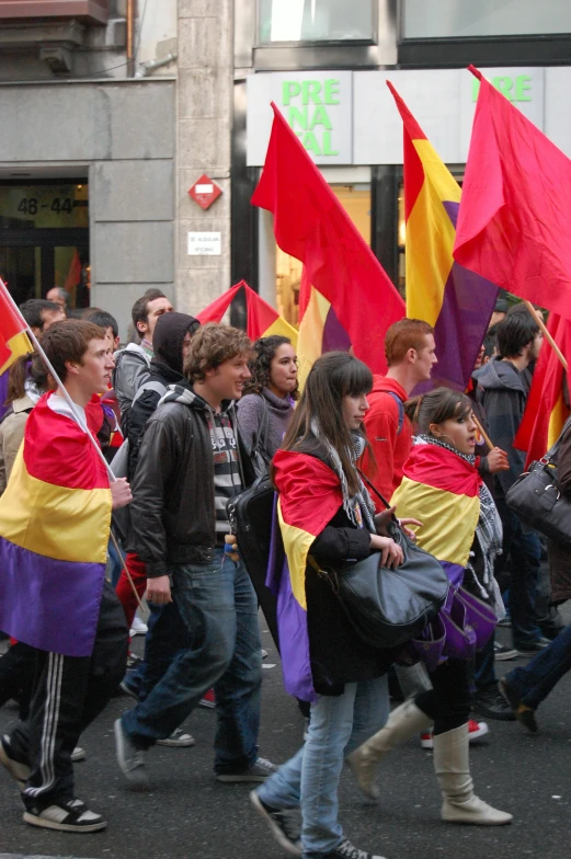 young men carrying flags walk down the street
