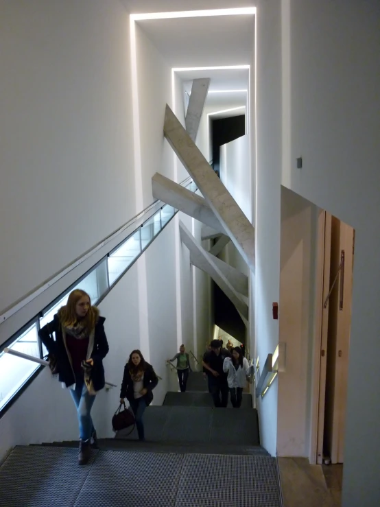 three woman walking up a stairwell, their hand in the air