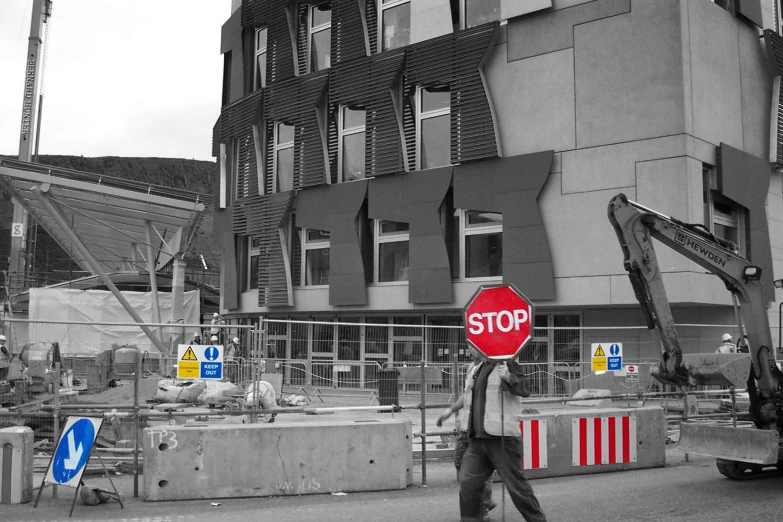 a man walking down the street with a stop sign