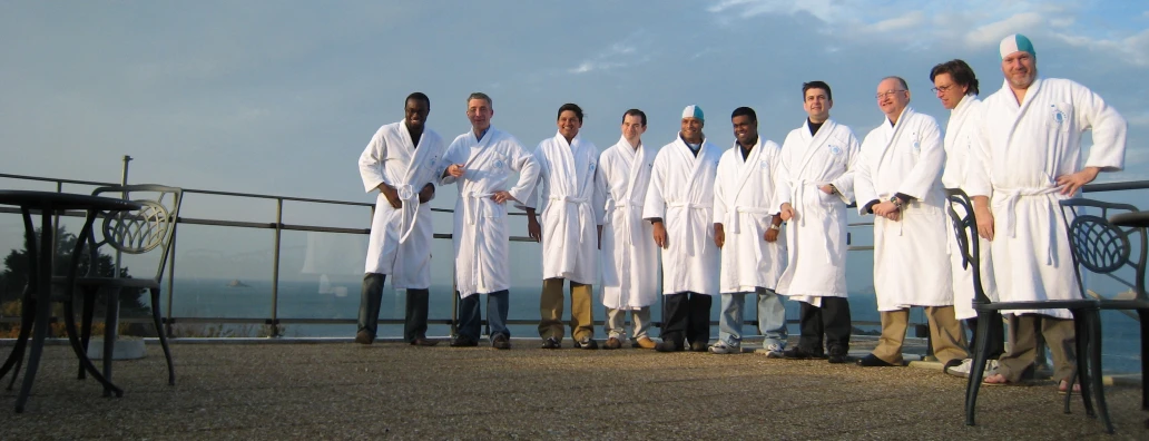 men are dressed in white robes on a roof