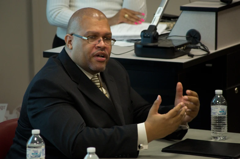 a man with glasses and a tie at a table