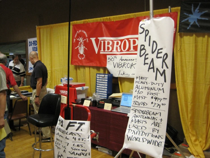 a group of people standing next to tables with various items on them