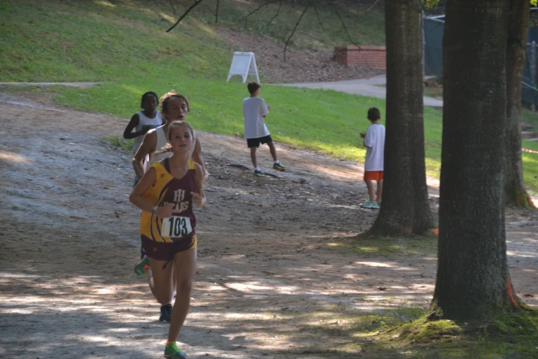 a young woman running through a park on a trail