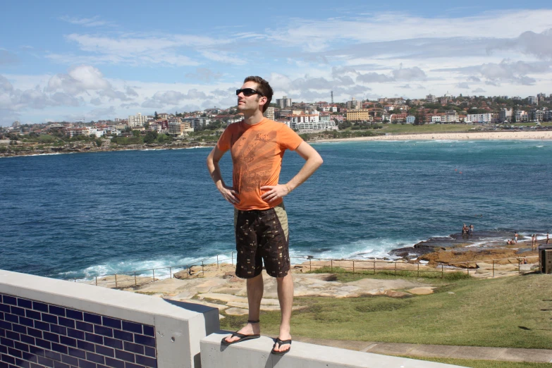 a man standing on top of a sidewalk in front of the ocean