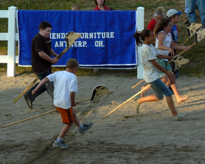 children playing a game of softball in an open area