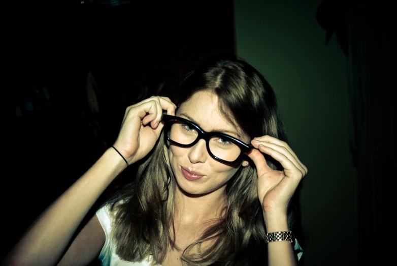 a girl in glasses and with her hands near her face