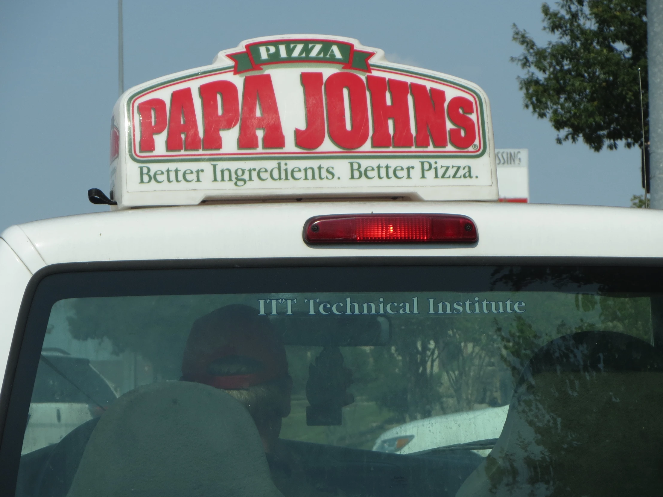 the back of a parked pizza van that has a sign on it that reads papa john's better ingredients, better pizza