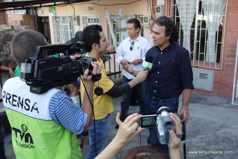 several people surround a pographer, filming the event