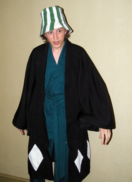 a child wearing a black kimono and hat with green trim